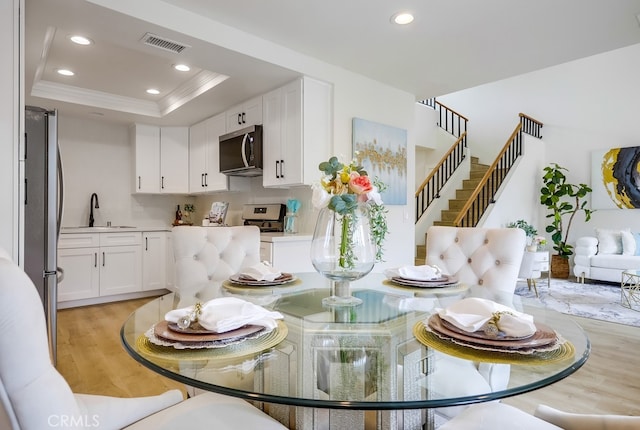 658 S Webster Ave Unit 4, Anaheim, CA 92804 - dining room with light wood-type flooring, recessed lighting, ornamental molding, stairway, and a tray ceiling
