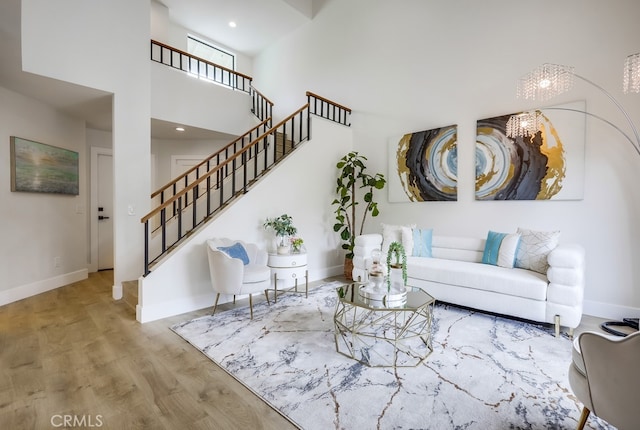 658 S Webster Ave Unit 4, Anaheim, CA 92804 - living area with stairway, baseboards, wood finished floors, a towering ceiling, and a chandelier