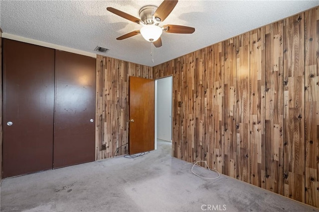 1254 Fieldgate Ave, Hacienda Heights, CA 91745 - unfurnished bedroom with wooden walls, a textured ceiling, carpet floors, a closet, and ceiling fan