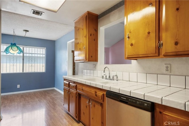 1254 Fieldgate Ave, Hacienda Heights, CA 91745 - kitchen featuring dishwashing machine, light wood-style flooring, brown cabinetry, and tile counters