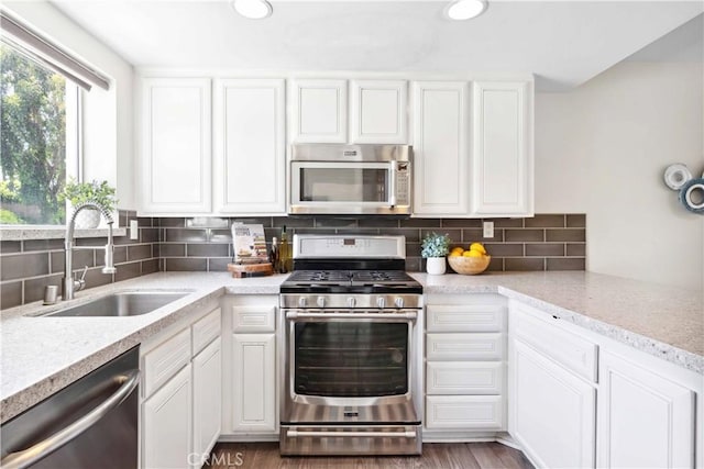 24833 Nueva Vista Dr Unit 2, Laguna Niguel, CA 92677 - kitchen featuring stainless steel appliances, a sink, light countertops, white cabinets, and decorative backsplash
