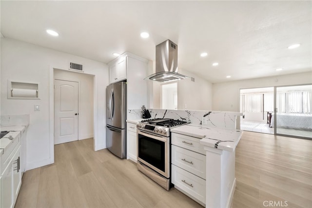 17121 Granada Ln, Huntington Beach, CA 92647 - kitchen featuring appliances with stainless steel finishes, wall chimney range hood, light wood finished floors, white cabinetry, and light stone counters