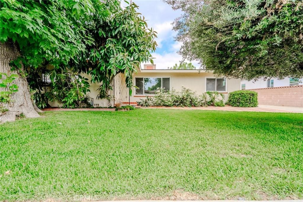 715 N San Antonio Ave, Ontario, CA 91762 - view of front facade featuring stucco siding and a front yard