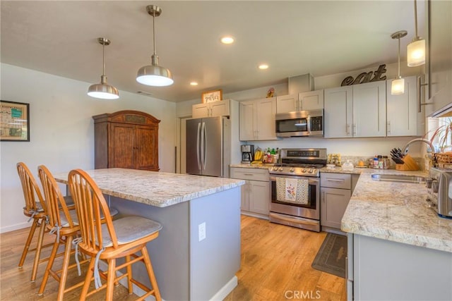 233 E Swift St, Orland, CA 95963 - kitchen featuring appliances with stainless steel finishes, light wood-style flooring, recessed lighting, a breakfast bar, and a center island
