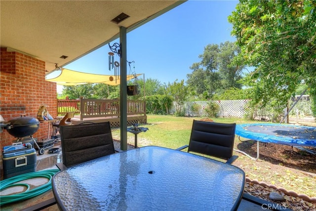 233 E Swift St, Orland, CA 95963 - view of patio featuring outdoor dining space, a trampoline, and a wooden deck