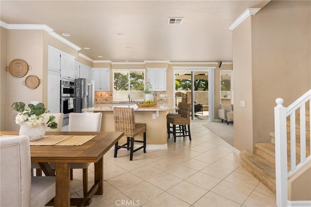 11 Berlamo, Rancho Santa Margarita, CA 92688 - dining room with light tile patterned floors, stairs, crown molding, recessed lighting, and baseboards