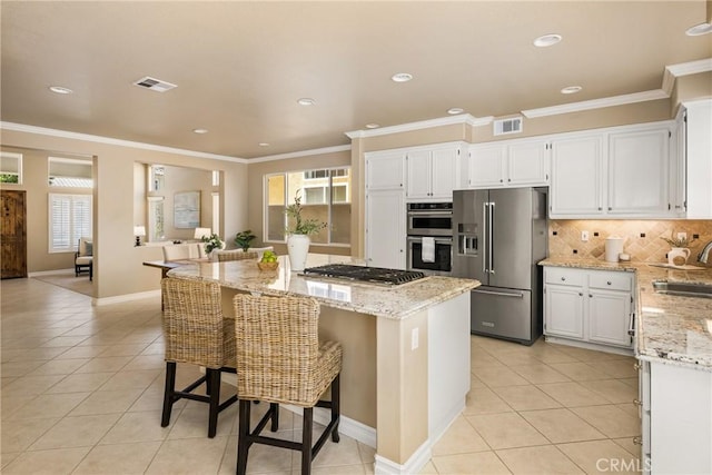 11 Berlamo, Rancho Santa Margarita, CA 92688 - kitchen featuring appliances with stainless steel finishes, a sink, light tile patterned floors, light stone counters, and a kitchen island
