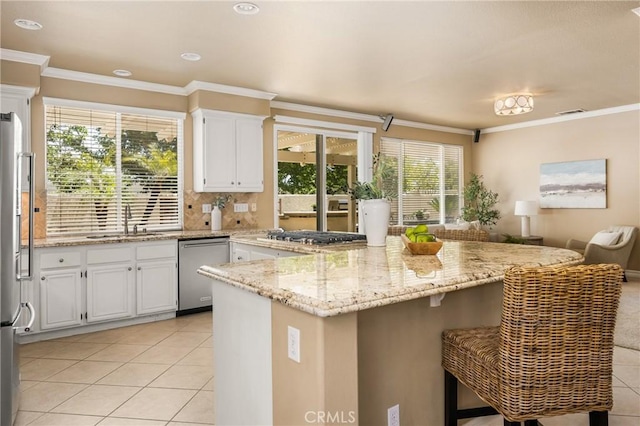 11 Berlamo, Rancho Santa Margarita, CA 92688 - kitchen with appliances with stainless steel finishes, a sink, light tile patterned flooring, white cabinets, and crown molding