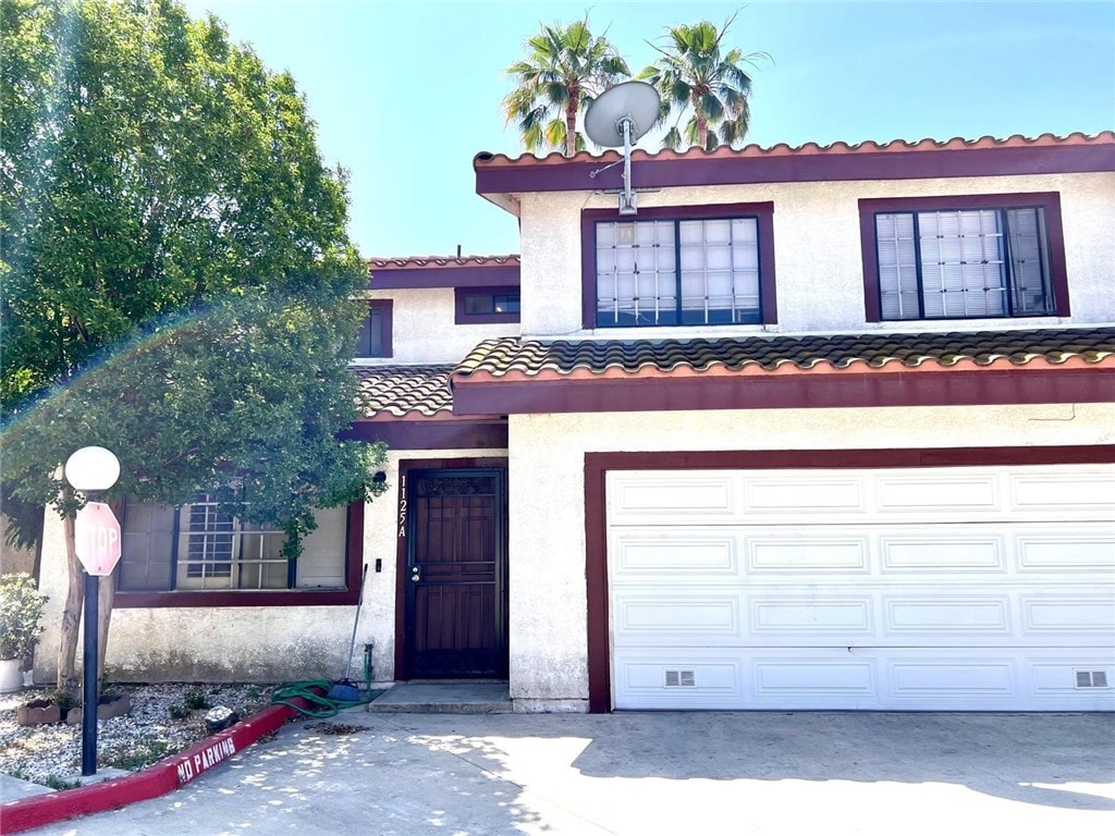 1125 Grand Ave E Unit A, Pomona, CA 91766 - view of front facade featuring a tiled roof, an attached garage, and stucco siding