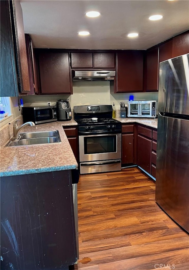 1125 Grand Ave E Unit A, Pomona, CA 91766 - kitchen featuring appliances with stainless steel finishes, under cabinet range hood, dark wood-style flooring, light countertops, and recessed lighting