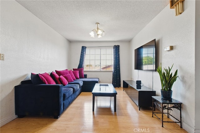 302 E 213th St, Carson, CA 90745 - living room featuring healthy amount of natural light, light wood finished floors, a chandelier, a textured ceiling, and a textured wall