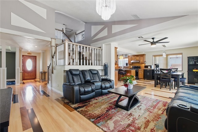 302 E 213th St, Carson, CA 90745 - living area featuring lofted ceiling, ceiling fan, light wood-style floors, stairs, and a chandelier