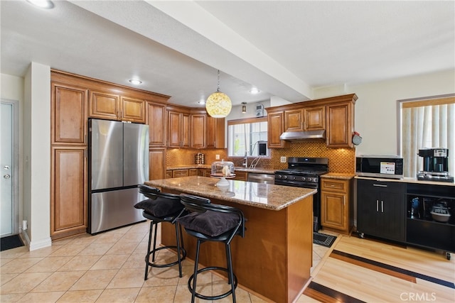 302 E 213th St, Carson, CA 90745 - kitchen featuring stainless steel appliances, under cabinet range hood, brown cabinetry, and recessed lighting