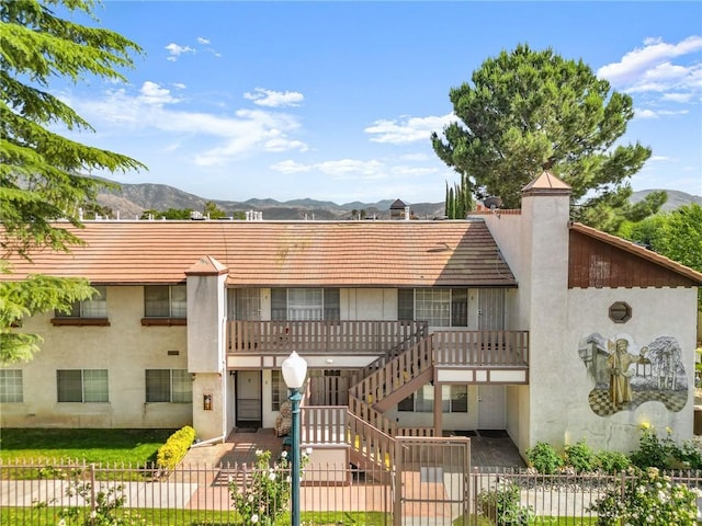 3880 W Jacinto View Rd Unit D, Banning, CA 92220 - view of building exterior with a fenced front yard, a mountain view, and stairs