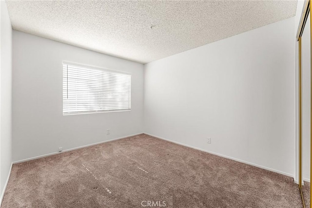 3880 W Jacinto View Rd Unit D, Banning, CA 92220 - empty room featuring carpet flooring, a textured ceiling, and baseboards