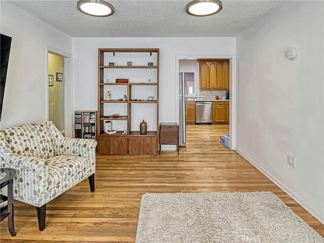 5436 Bonfair Ave, Lakewood, CA 90712 - living area featuring a textured ceiling and light wood-style flooring
