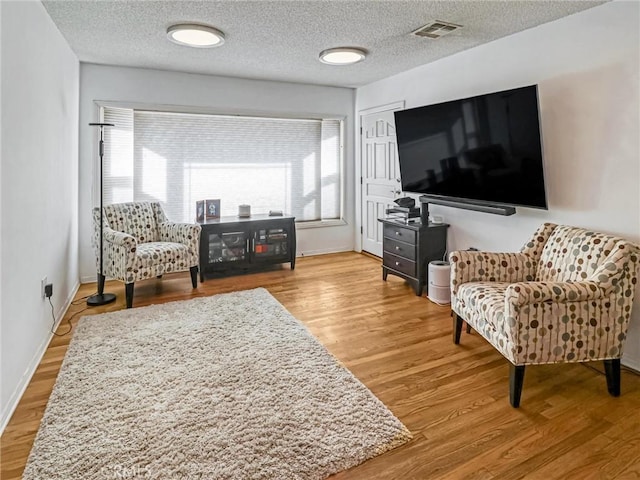 5436 Bonfair Ave, Lakewood, CA 90712 - living room featuring wood finished floors, baseboards, and a textured ceiling