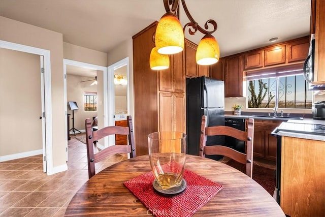 380 Mack Ln Unit 29, Palms, CA 92277 - kitchen featuring freestanding refrigerator, tile patterned flooring, ceiling fan, brown cabinets, and decorative light fixtures