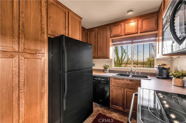 380 Mack Ln Unit 29, Palms, CA 92277 - kitchen featuring black appliances, a sink, brown cabinets, dark tile patterned flooring, and light countertops