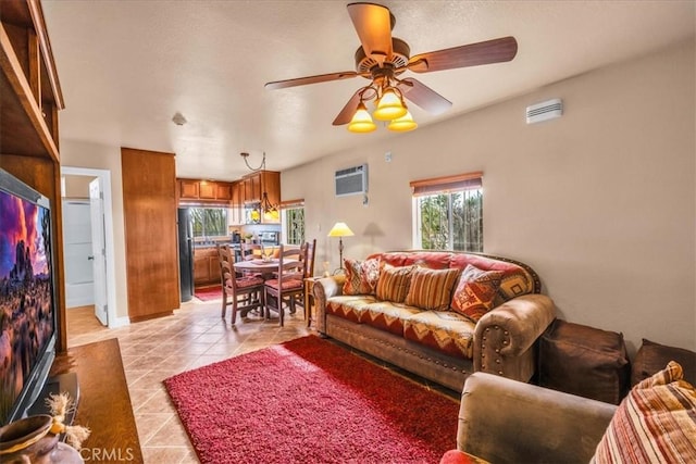 380 Mack Ln Unit 29, Palms, CA 92277 - living room featuring light tile patterned flooring, a wall unit AC, ceiling fan, and baseboards