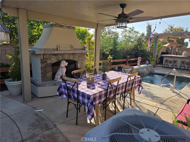 25687 Red Hawk Rd, Corona, CA 92883 - view of patio featuring an outdoor stone fireplace, central AC unit, an outdoor bar, outdoor dining space, and a ceiling fan