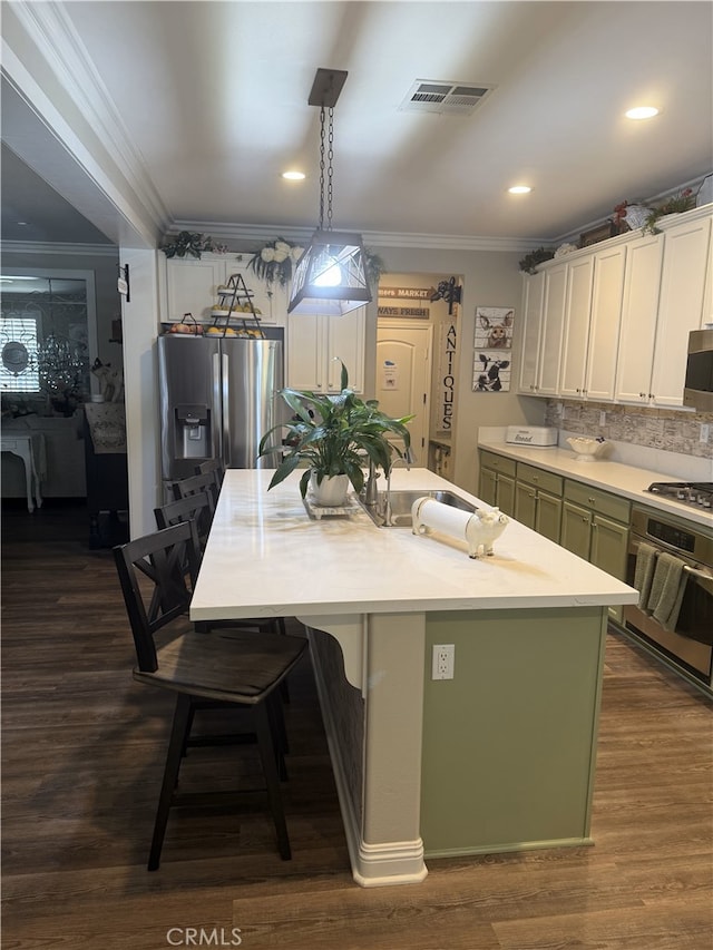 25687 Red Hawk Rd, Corona, CA 92883 - kitchen with appliances with stainless steel finishes, ornamental molding, light countertops, a kitchen island with sink, and tasteful backsplash
