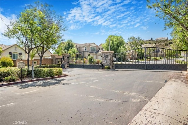 25687 Red Hawk Rd, Corona, CA 92883 - view of asphalt street featuring street lighting, a gate, a residential view, and a gated entry