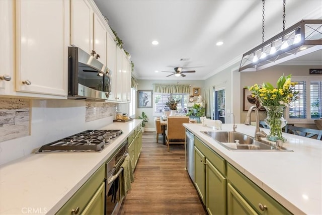 25687 Red Hawk Rd, Corona, CA 92883 - kitchen with appliances with stainless steel finishes, green cabinets, ornamental molding, dark wood-style flooring, and light countertops