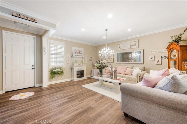 25687 Red Hawk Rd, Corona, CA 92883 - living area featuring light wood-style floors, a chandelier, crown molding, recessed lighting, and a fireplace with raised hearth