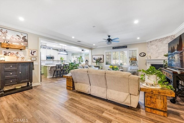 25687 Red Hawk Rd, Corona, CA 92883 - living room featuring crown molding, ceiling fan, light wood-type flooring, recessed lighting, and a fireplace