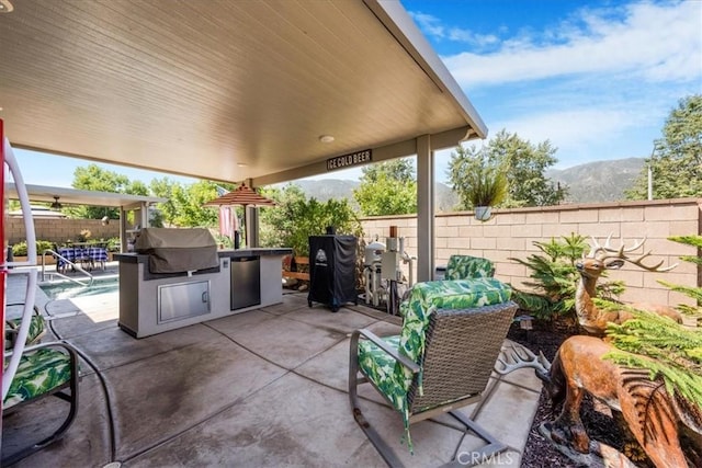 25687 Red Hawk Rd, Corona, CA 92883 - fenced backyard with exterior kitchen, a patio area, and a mountain view