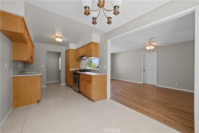 26111 Abdale St, Newhall, CA 91321 - kitchen featuring stainless steel gas range oven, a sink, open floor plan, light countertops, and a chandelier