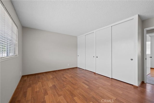 26111 Abdale St, Newhall, CA 91321 - unfurnished bedroom with wood finished floors, multiple closets, and a textured ceiling