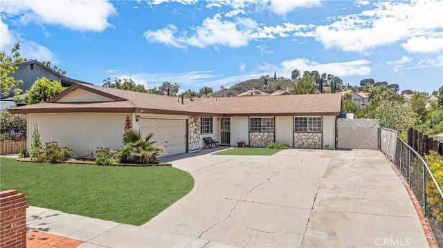26111 Abdale St, Newhall, CA 91321 - ranch-style home featuring concrete driveway, a garage, and stone siding