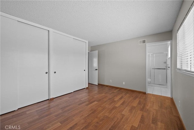 26111 Abdale St, Newhall, CA 91321 - unfurnished bedroom with wood finished floors, a textured ceiling, and ensuite bath