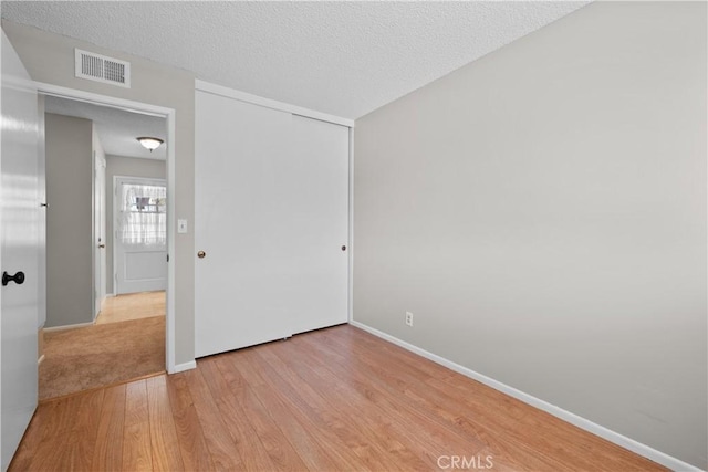 26111 Abdale St, Newhall, CA 91321 - unfurnished bedroom with light wood-style flooring, baseboards, a closet, and a textured ceiling