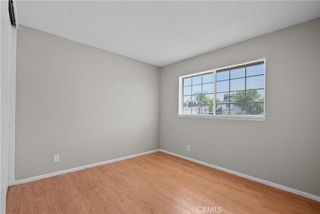 26111 Abdale St, Newhall, CA 91321 - spare room featuring light wood-style floors, baseboards, and a textured ceiling