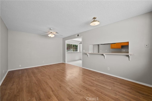 26111 Abdale St, Newhall, CA 91321 - unfurnished living room featuring a ceiling fan, wood finished floors, a textured ceiling, and baseboards