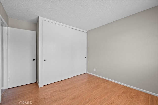 26111 Abdale St, Newhall, CA 91321 - unfurnished bedroom with light wood-type flooring, a closet, a textured ceiling, and baseboards