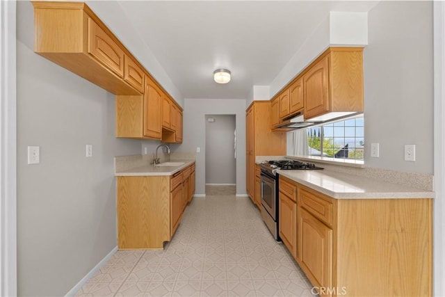 26111 Abdale St, Newhall, CA 91321 - kitchen featuring stainless steel gas range, a sink, baseboards, light countertops, and under cabinet range hood