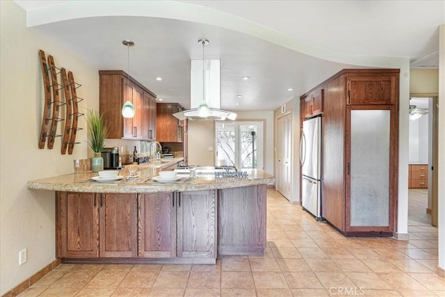 1256 Bostonia St Unit B, El Cajon, CA 92021 - kitchen with freestanding refrigerator, a peninsula, brown cabinets, a sink, and recessed lighting
