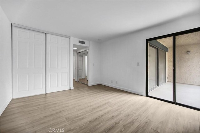 4499 Via Marisol Unit 105A, Los Angeles, CA 90042 - unfurnished bedroom with wood finished floors, access to exterior, and baseboards