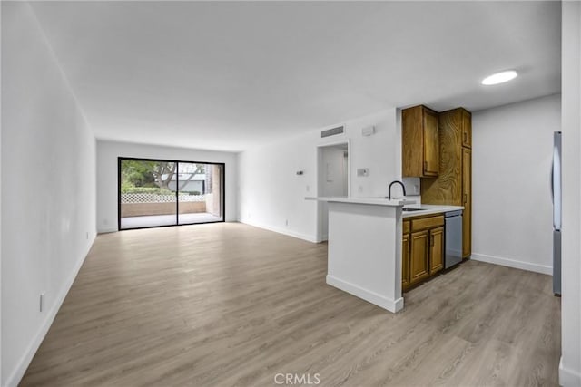 4499 Via Marisol Unit 105A, Los Angeles, CA 90042 - kitchen featuring appliances with stainless steel finishes, brown cabinets, open floor plan, a sink, and light countertops