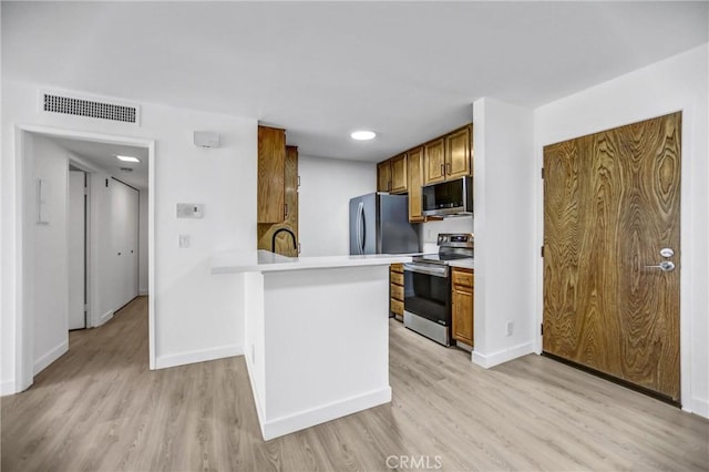 4499 Via Marisol Unit 105A, Los Angeles, CA 90042 - kitchen with appliances with stainless steel finishes, light countertops, baseboards, light wood-style flooring, and a peninsula