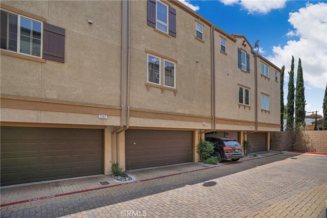 14120 W Willow Ln, Van Nuys, CA 91405 - back of house with a garage, driveway, and stucco siding