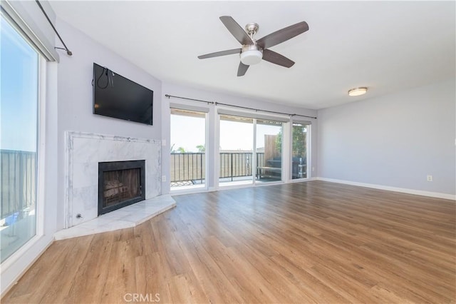 2244 Molino Ave, Signal Hill, CA 90755 - unfurnished living room featuring light wood-style flooring, baseboards, a tile fireplace, and a ceiling fan