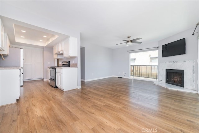 2244 Molino Ave, Signal Hill, CA 90755 - unfurnished living room featuring a fireplace, a ceiling fan, light wood finished floors, a tray ceiling, and recessed lighting