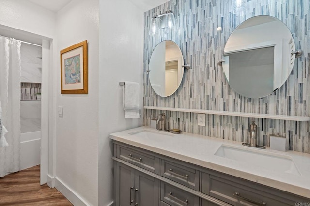 600 N The Strand Unit 3, Oceanside, CA 92054 - full bath featuring double vanity, shower / bath combo with shower curtain, wood finished floors, baseboards, and decorative backsplash
