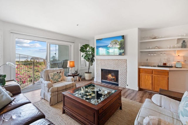 600 N The Strand Unit 3, Oceanside, CA 92054 - living area featuring light wood finished floors, a fireplace, and bar with sink
