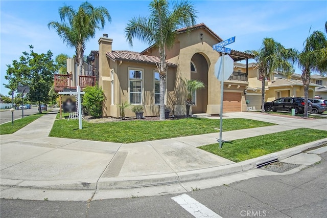 2983 Orchid Ln, Turlock, CA 95382 - mediterranean / spanish-style house with an attached garage, driveway, stucco siding, and a front lawn